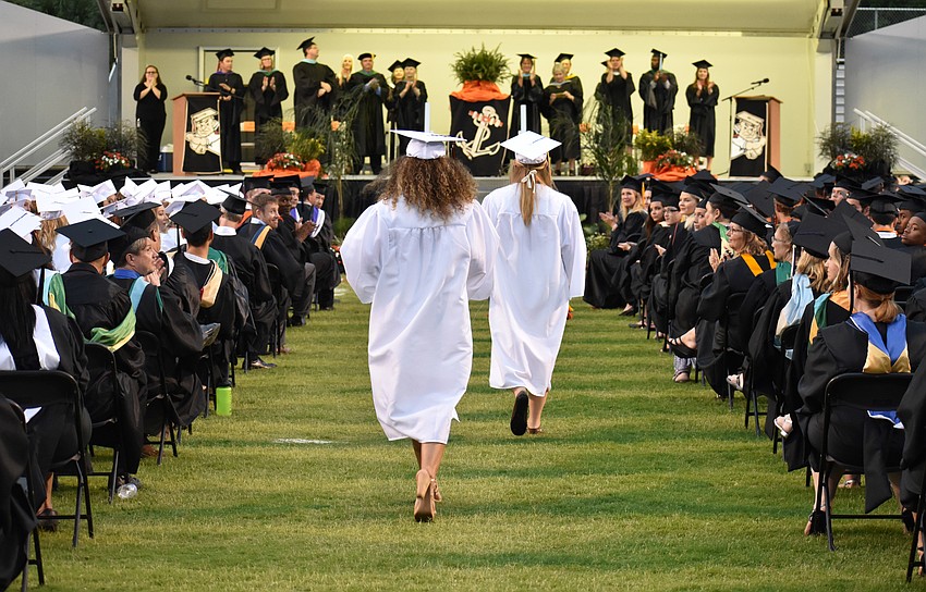 Student speakers approach the stage during Sarasota High School graduation at Cleland Stadium at Ihrig Field.
