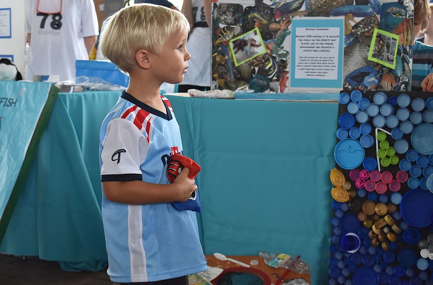 Derik Hardesty listens to the rules of cornhole at World Oceans Day on June 3 at Mote Aquarium.