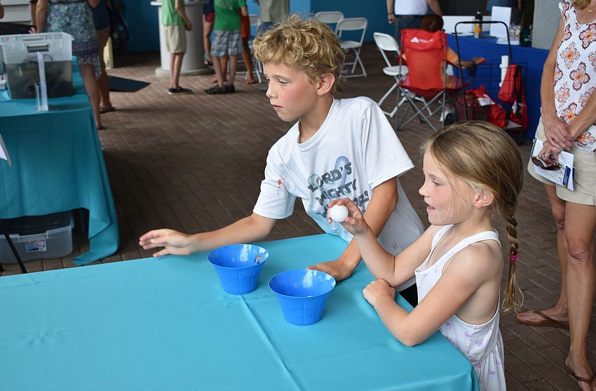 Zach Zeleskey and his sister Maggie Zeleskey aim their ping-pong balls at several buckets during a game at World Oceans Day on June 3 at Mote Aquarium.