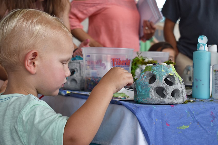 Ryder Dagenais paints a ceramic aquarium decoration at World Oceans Day on June 3 at Mote Aquarium.