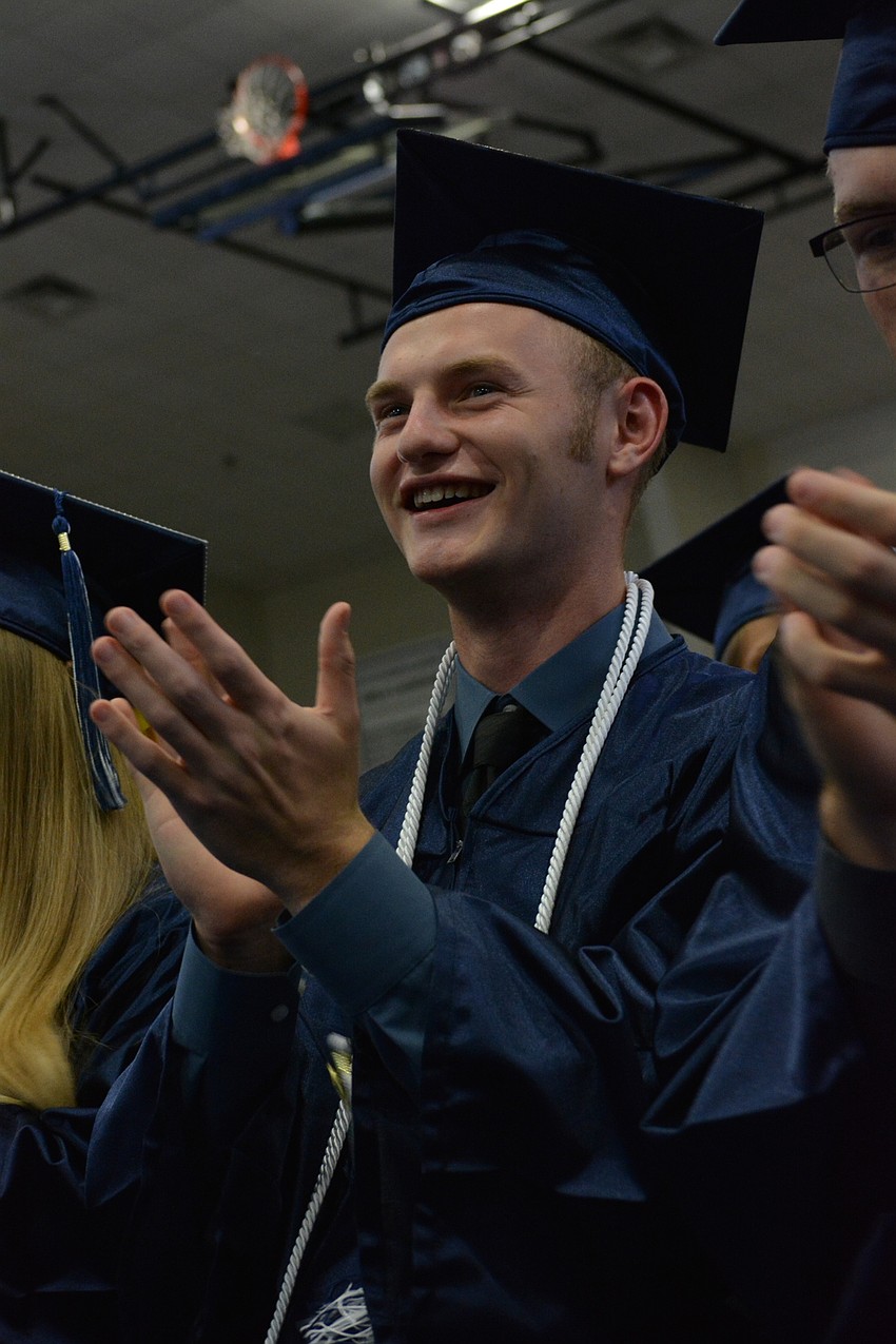 Cody Cheney smiles and claps for his best friend, senior speaker Nicholas Murphy, and his witty speech, titled 