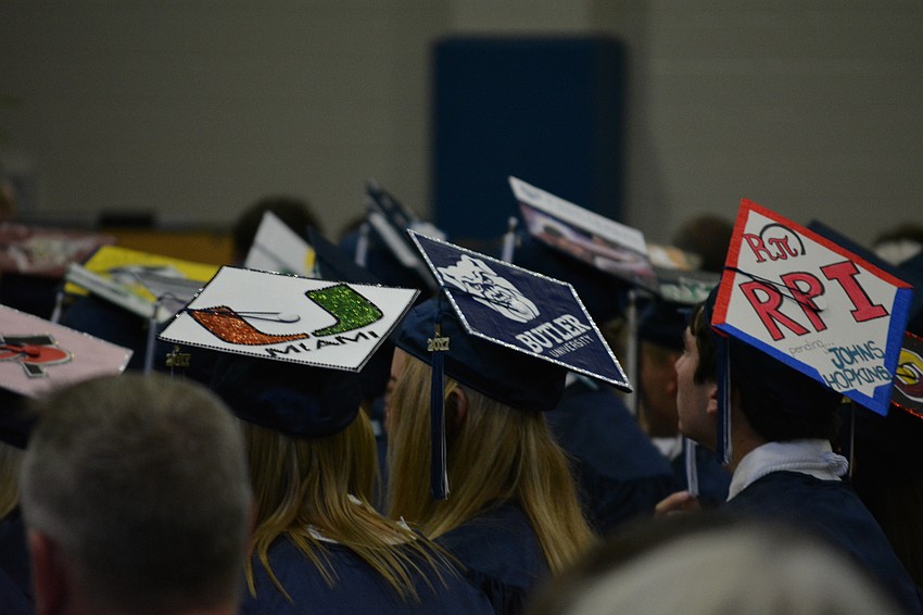 Seniors decorate their caps with their emblems for their future colleges.