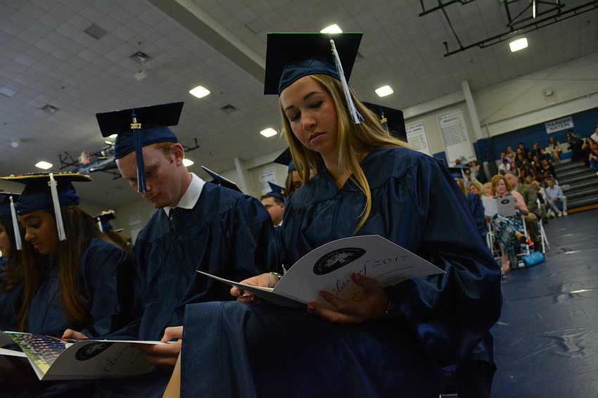 Savannah Alario, a future University of Miami , led the procession. She checks out the bulletin during the start of the ceremony.