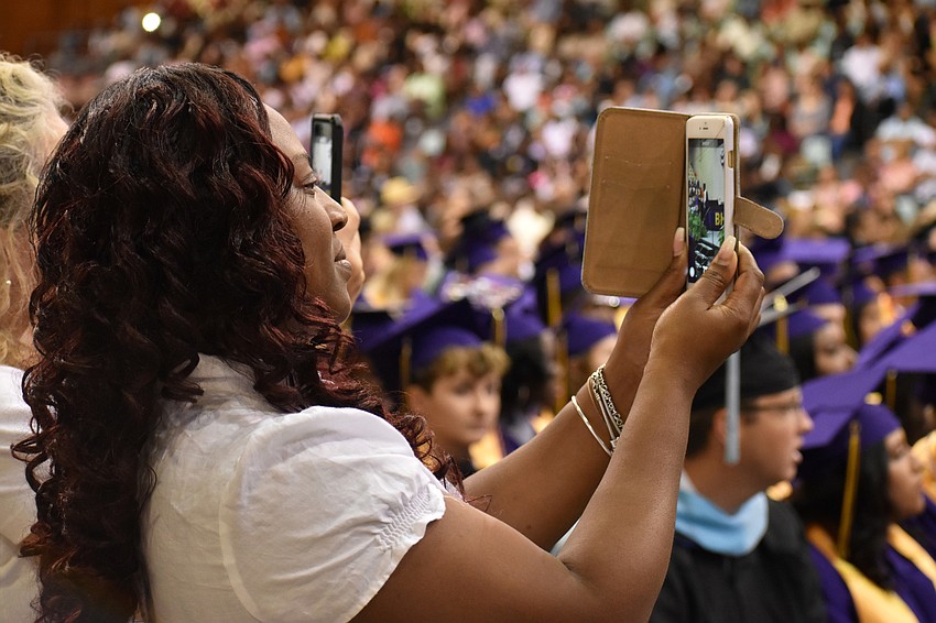 Latoya Oliver, one of the women student speaker Daquone Tirene referred to as part of his support group of many mothers, records his speech during the Booker High School Graduation on June 3 at Robarts Arena.