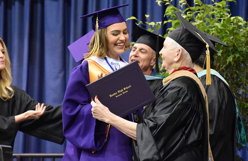 Sarasota County School Board Chairwoman Caroline Zucker awards a graduate with her diploma during the Booker High School Graduation on June 3 at Robarts Arena.