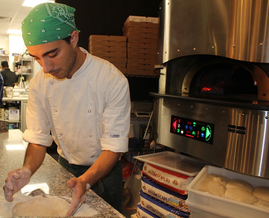 IL Conte Ristorante & Pizzeria&#39;s pizzaiolo (pizza maker) Simone Dimarco prepares the dough for the pizza he is about to make.