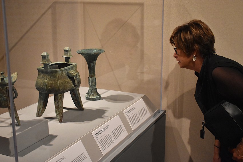 Marie Pender observes wine vessels from the late Shang dynasty at the Eternal Offerings: Chinese Ritual Bronzes exhibit on June 7 at The Ringling.