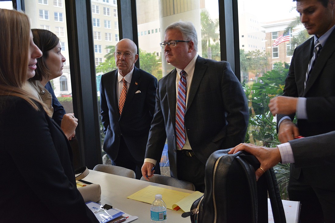 Project attorney Ed Vogler, center, regroups with his team after the meeting.