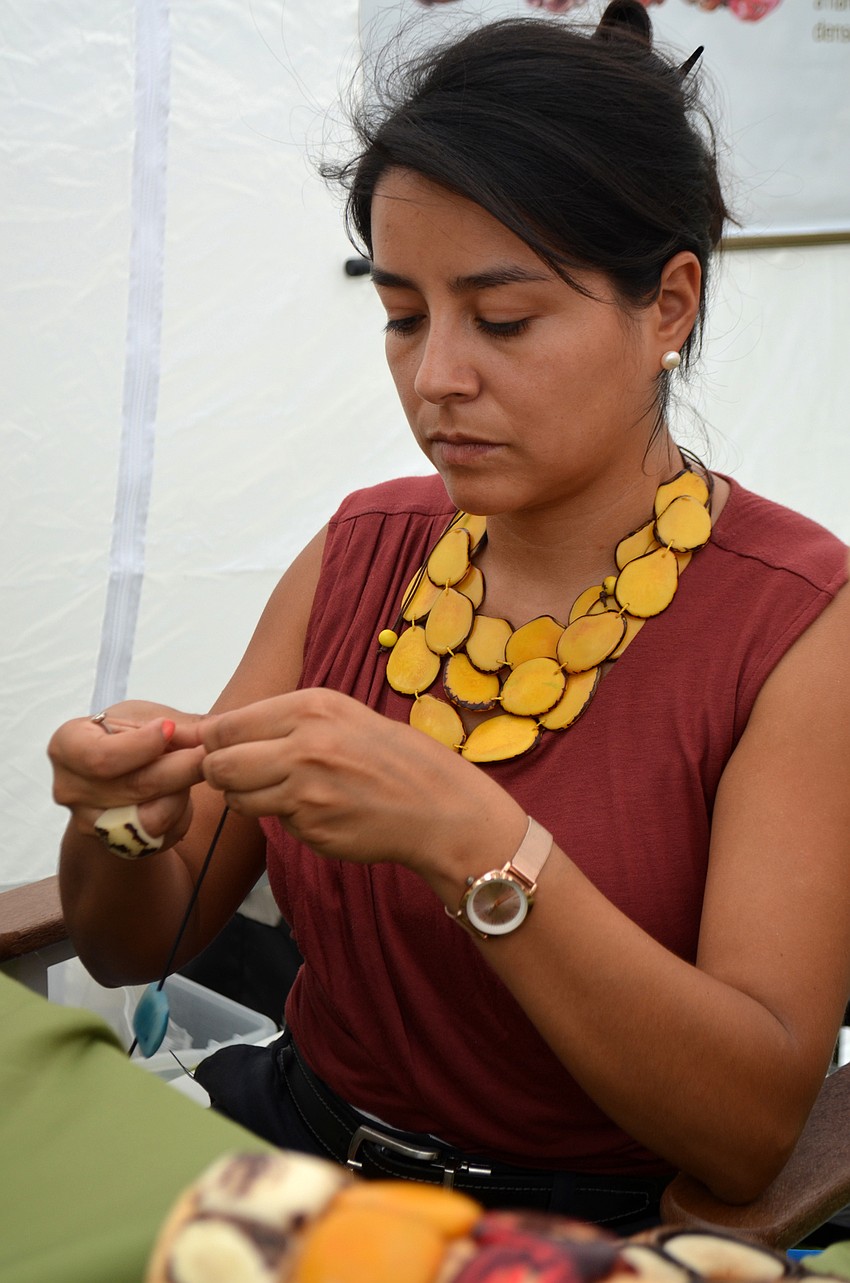 Vivian Bermudez works on a piece of eco-friendly jewelry during the craft festival.
