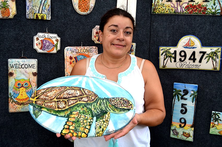 Mary Garcia poses with her artwork at the 16th annual St. Armands Circle Craft Festival.
