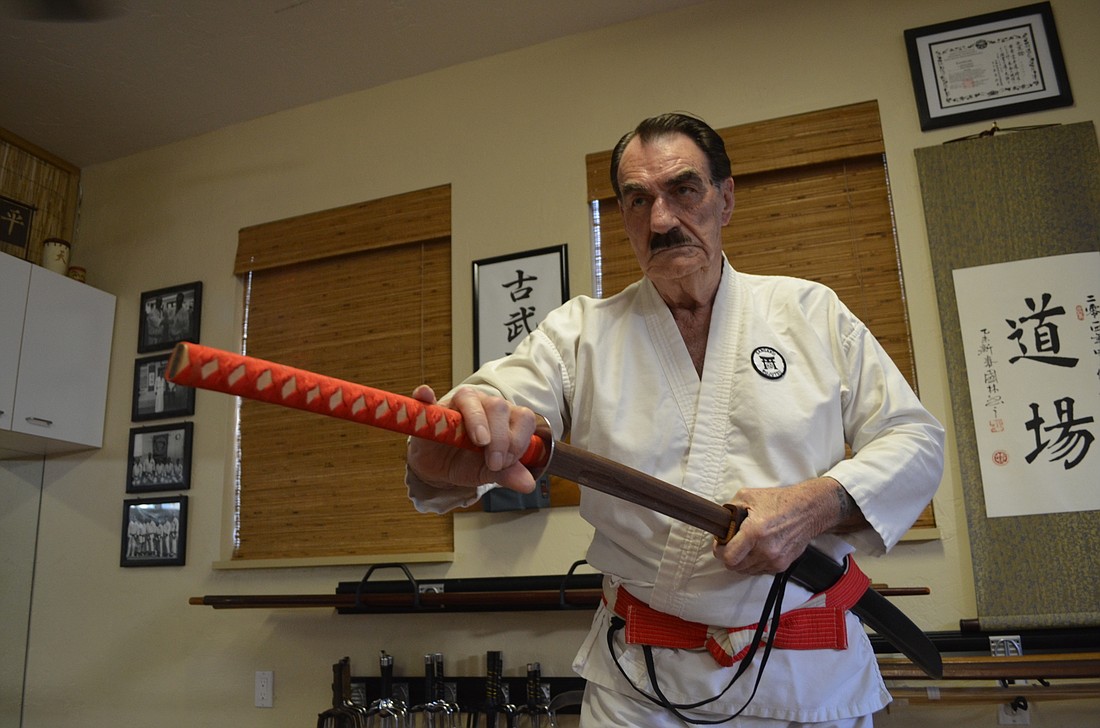 Horne unsheaths a custom sword he recently made. Photo by Nick Friedman