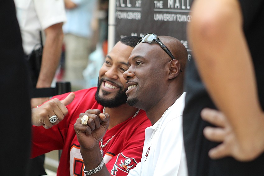 Former Tampa Bay Buccaneers players Michael Clayton and Dexter Jackson sign autographs and take photos during Dad's Day.