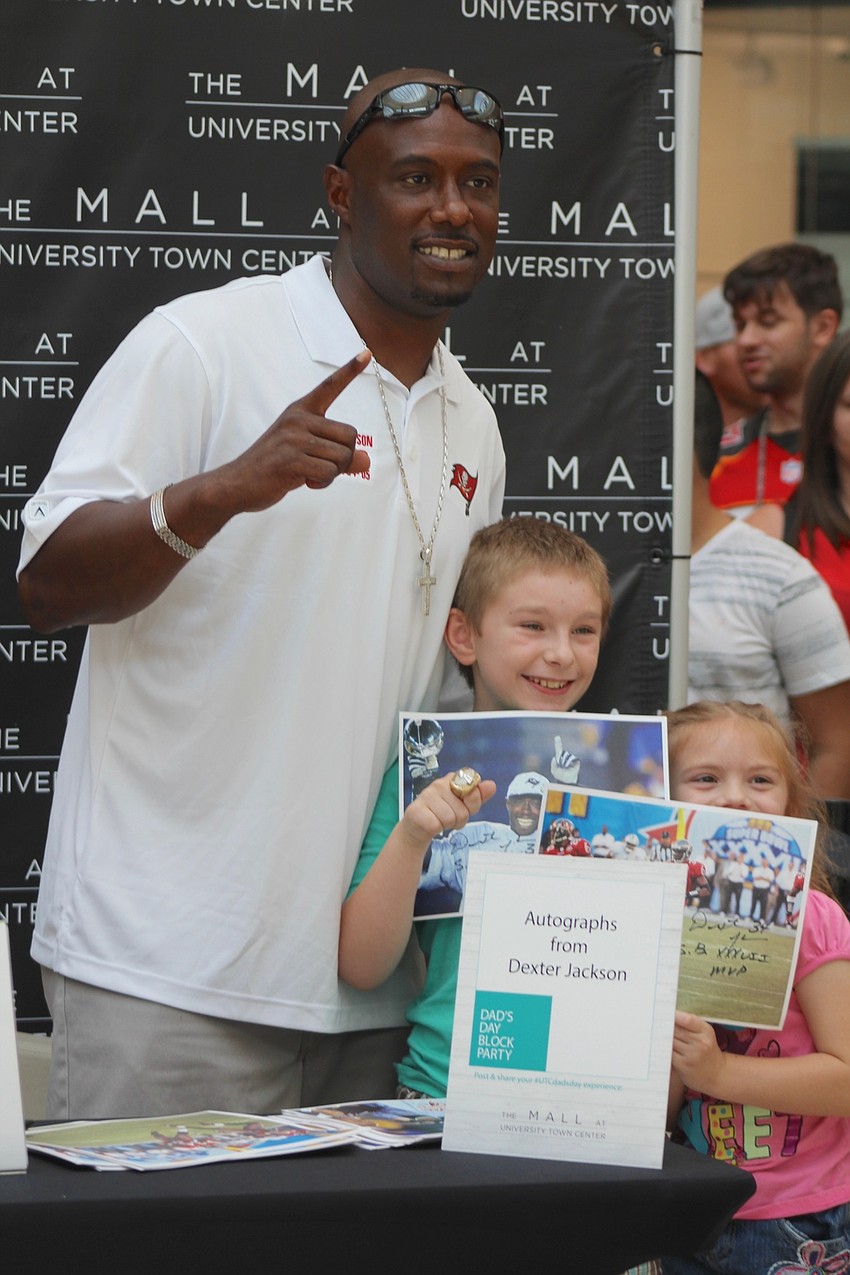 Former Buc Dexter Jackson, East County's Alex Webb and Joanna Webb show off their autographs.