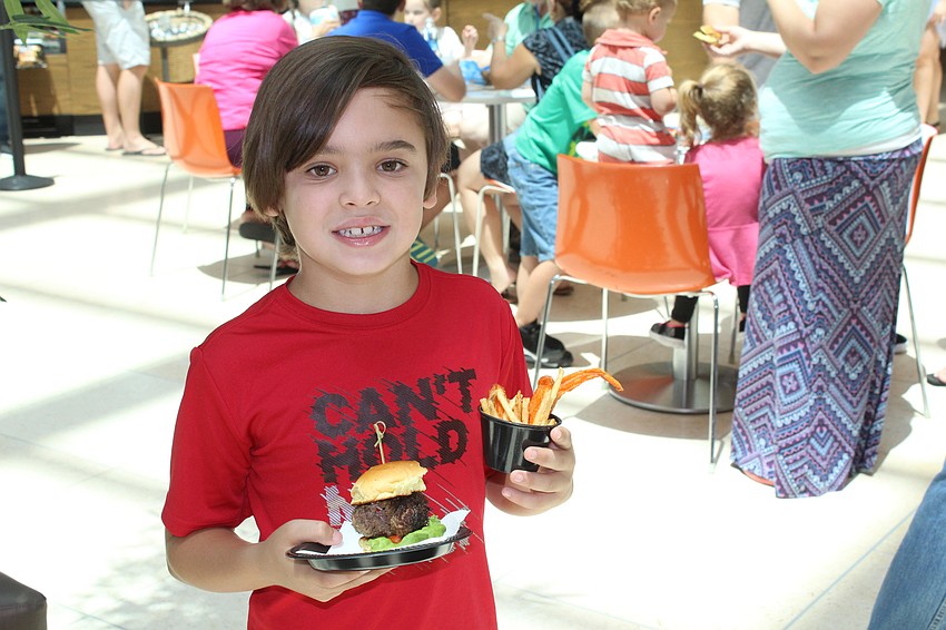 Sarasota's Ezra Smith munches on some free samples during Dad's Day.