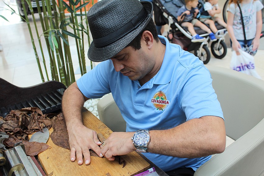 Lagui Leiva demonstrates how to make a cigar at Covadonga Cigars' booth during Dad's Day.
