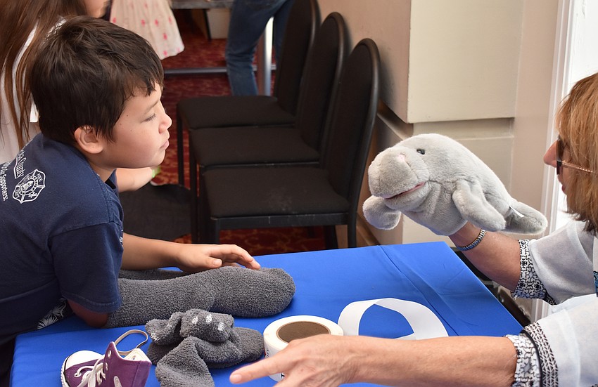 Peter Wovkonish learns about manatees from Barbara Prete, a volunteer at the South Florida Museum, at Asolo Family Day on June 17 at the FSU Center for the Performing Arts.