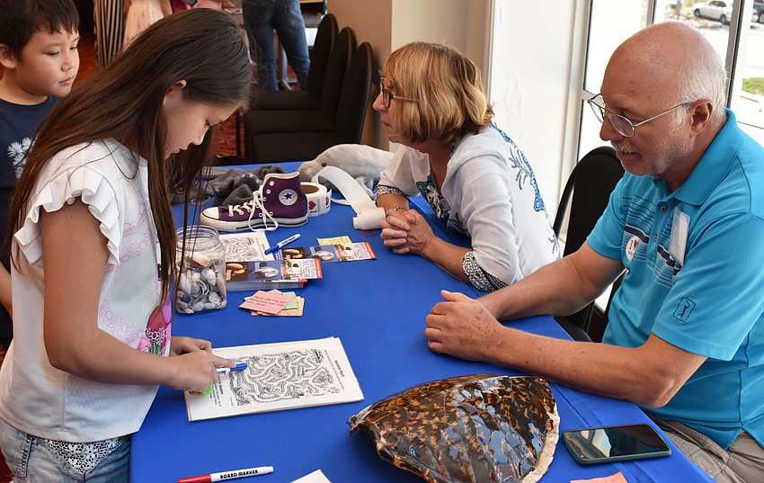 Leila Wovkonish works on a maze under the supervision of Ron Prete, a volunteer at the South Florida Museum, at Asolo Family Day on June 17 at the FSU Center for the Performing Arts.