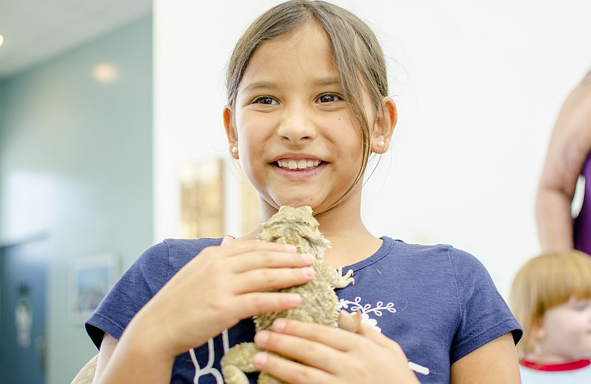 Caroline Cannon pets one of the two bearded dragons that were passed between campers.
