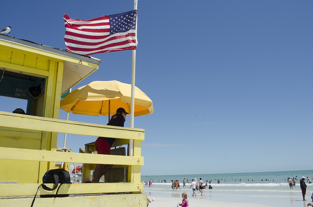 A lifeguard at Siesta Beach watches swimmers, ready to help if needed.