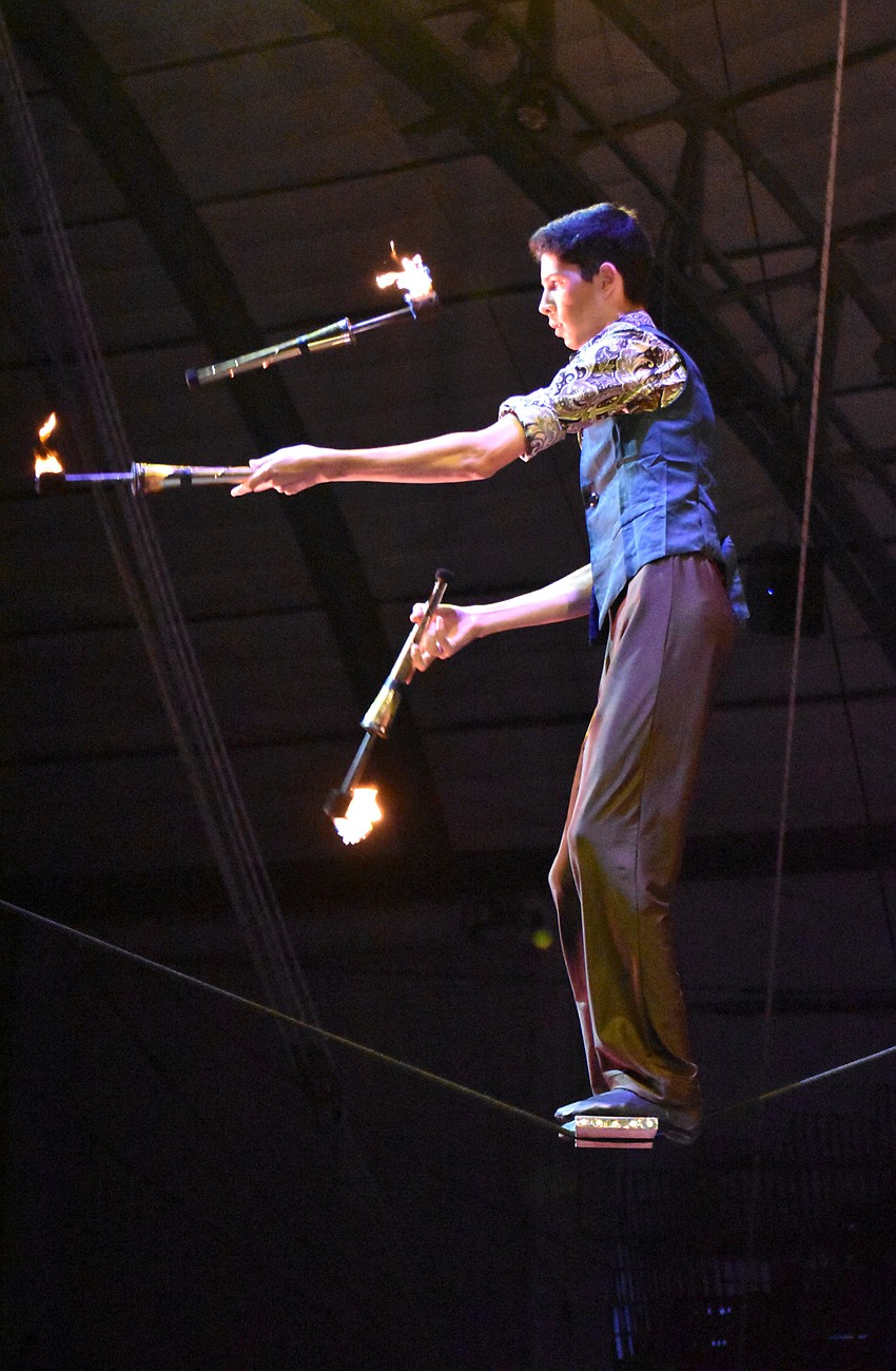 Jared Gracia-David juggles batons that were lit on fire while he walks the Slack Rope.