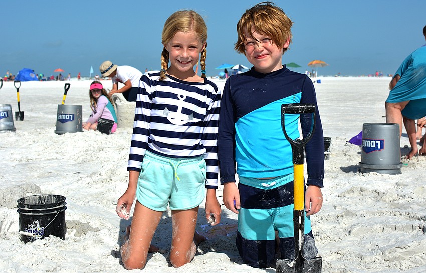 Sinclaire Scheiderer and Ezra Weinstein pose next to their sand sculptures.