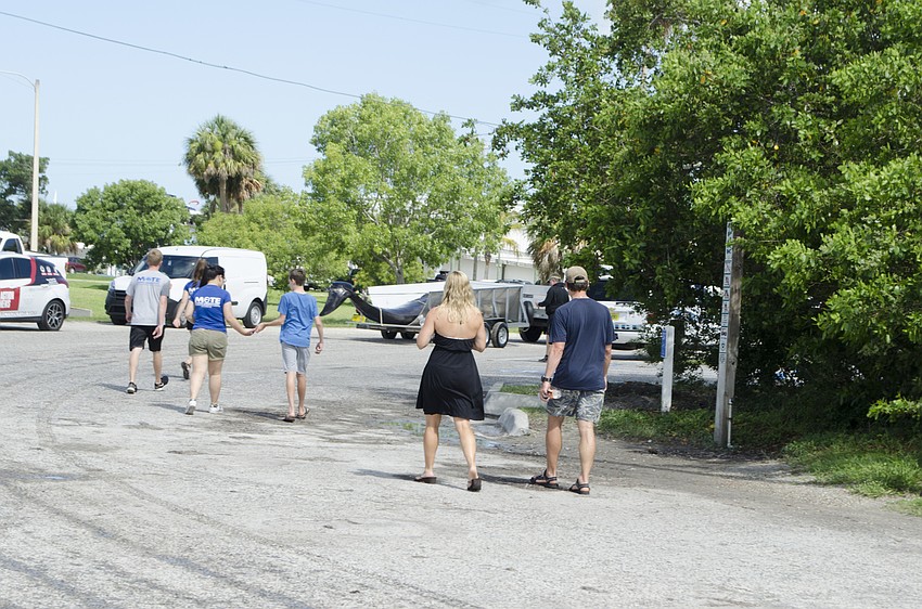 Bystanders and Mote employees watch the whale drive away.