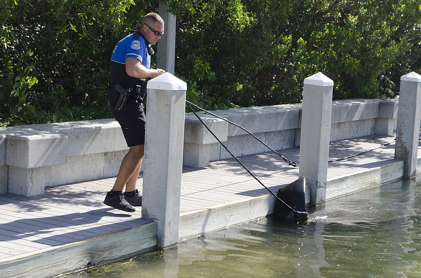 Officer Kenton Montegna with the Sarasota Police Department helped pull the whale into shallow water once the boat towed it in.