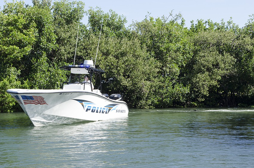 A law enforcement boat tows the whale to a boat ramp at Mote.