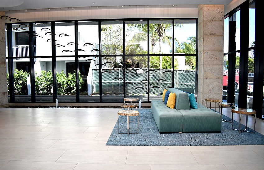 The lobby of Zota Beach resorts is open with high-ceilings. Two couches provide seating for guests.