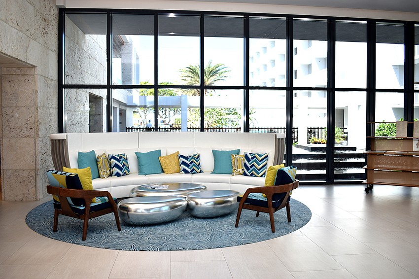 The lobby of Zota Beach resorts is open with high-ceilings. Two couches provide seating for guests.