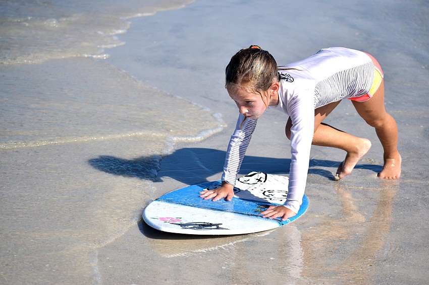 Gigi Tuffile gets ready to ride her skimboard along the shore of Lido Beach.