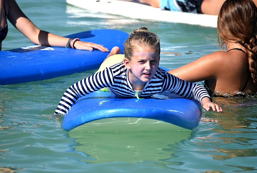 Mia Freeman paddles her surfboard around Lido Beach.