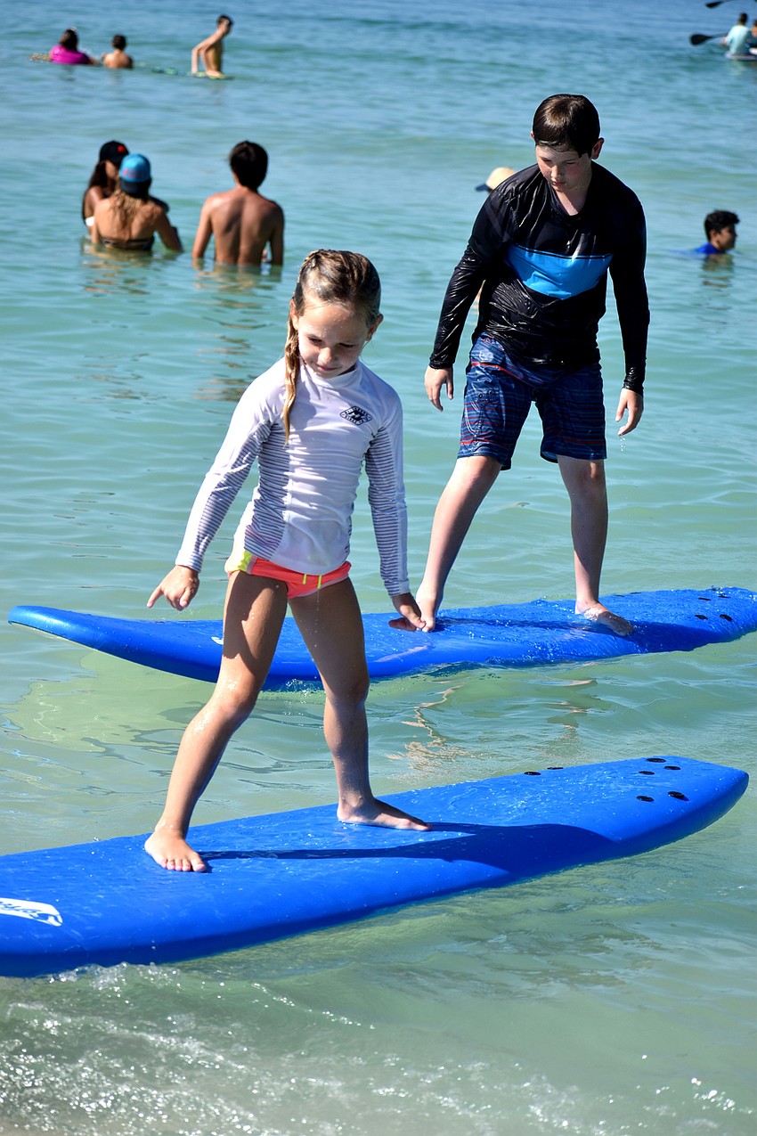 Gigi Tuffile and Magnus Shannon test out their surfing skills during Sarasota County’s Skim, Surf and Paddle Camp on June 28.