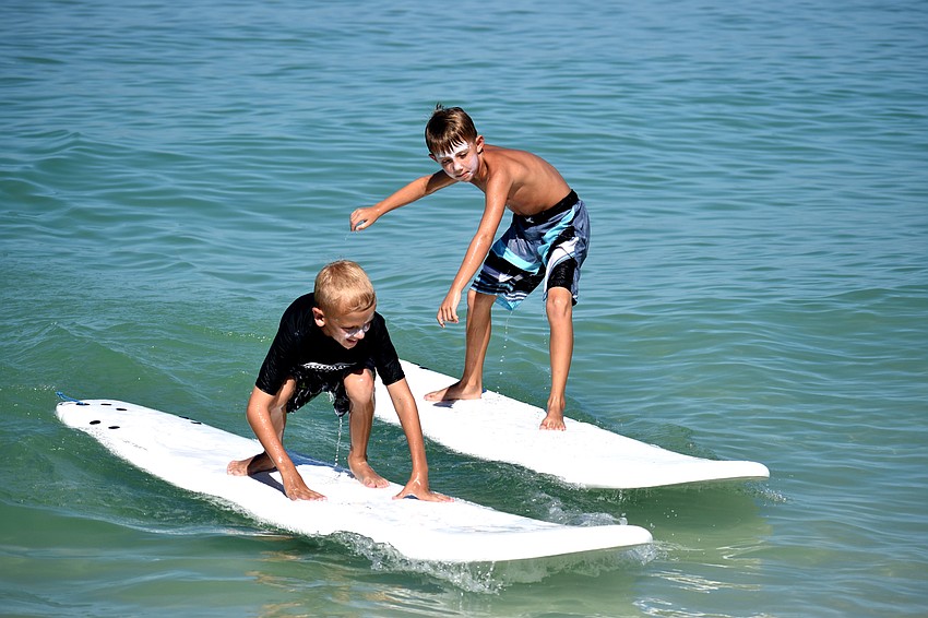 Chase Braune and Connor Helrigle work on their surfing skills.