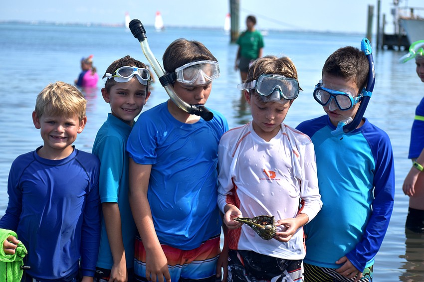 Gregory Budslick, Reef Teffenhart, Owen Bard, Lyric Finney and Miles Otchet check out the crab Finney found in New Pass Inlet.