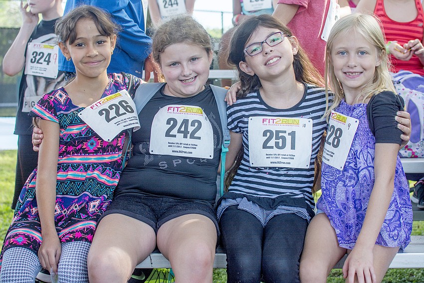 Carolina, Chloe, Desiree and Melanie pose with their racing bibs before the Fit2Run fun run at Boys and Girls club.