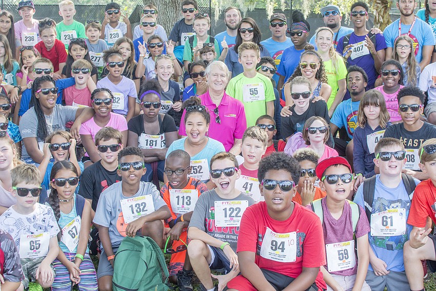 Boys and Girls Club members pose with Fit2Run owner Bill Robinson before participating in the Fit2Run fun run at Boys and Girls Club.