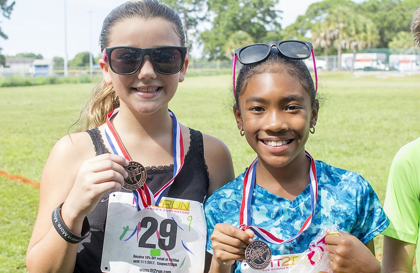 Top-finishers Arabella and Aaleeyah pose with their medals after the Fit2Run fun run.