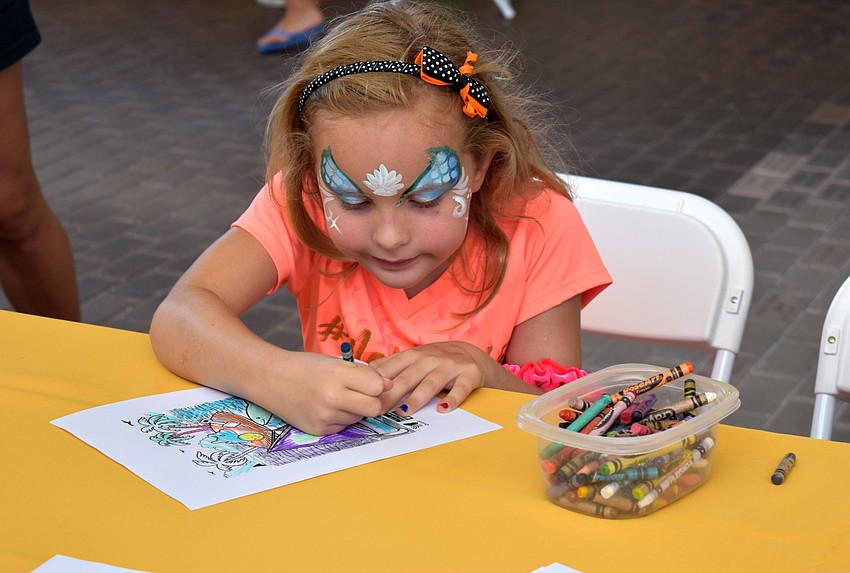 Gillian Masden colors a shark page during Mote’s Fins and Fun Family Festival.