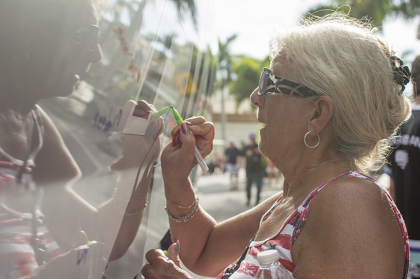 Jackie Ashe signs the Alex and Ani boat.
