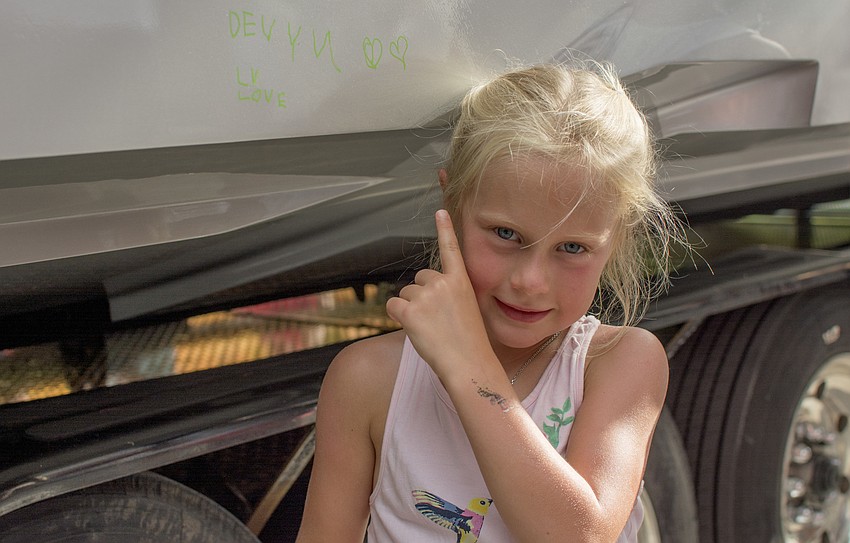 Devyn Speareer points to where she signed the Alex and Ani boat.