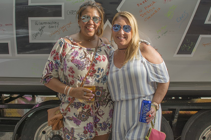 Celina Horton and Kelly Ballinger pose in front of the Alex and Ani boat