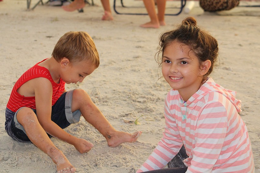 East County's Max McLaughlin and Chloe Adkins play in the sand before the fireworks show at Nathan Benderson Park.