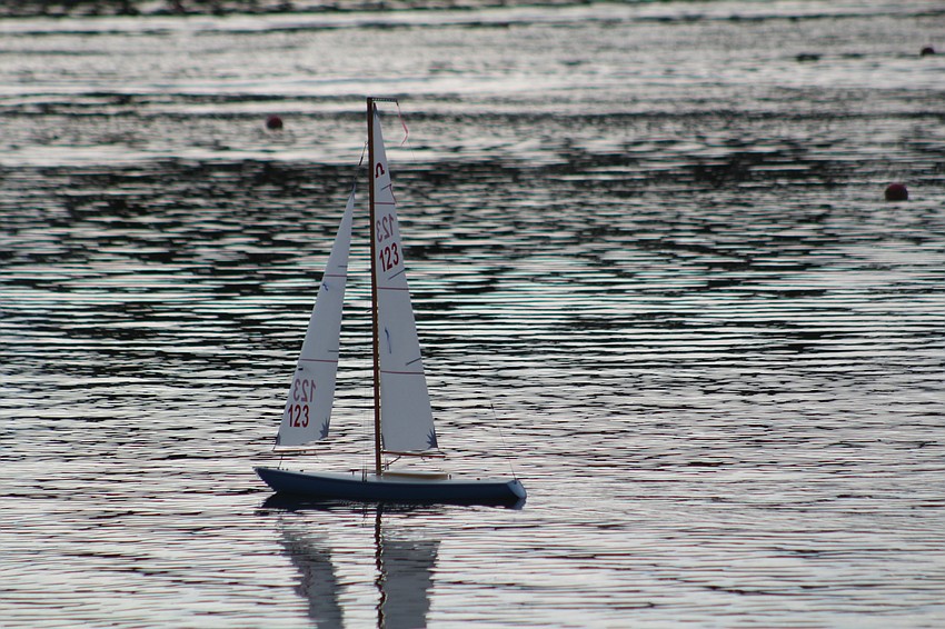 A remote control sailboat travels across the water at Nathan Benderson Park before the fireworks show.