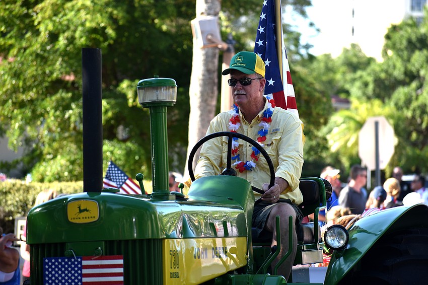 Steve Branham drives a tractor pulling the Longboat Key Garden Club float.