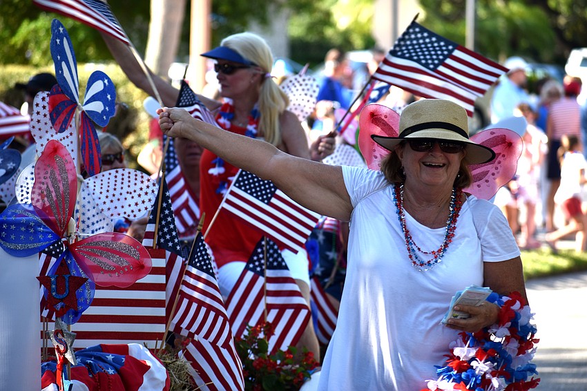 JoAnne Schwencke of the  Longboat Key Garden Club waves to the crowd on Bay Isles Road.