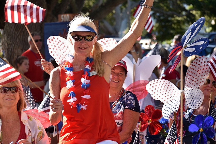 Longboat Key Garden Club President Susan Phillips waves to the crowd on Bay Isles Road.
