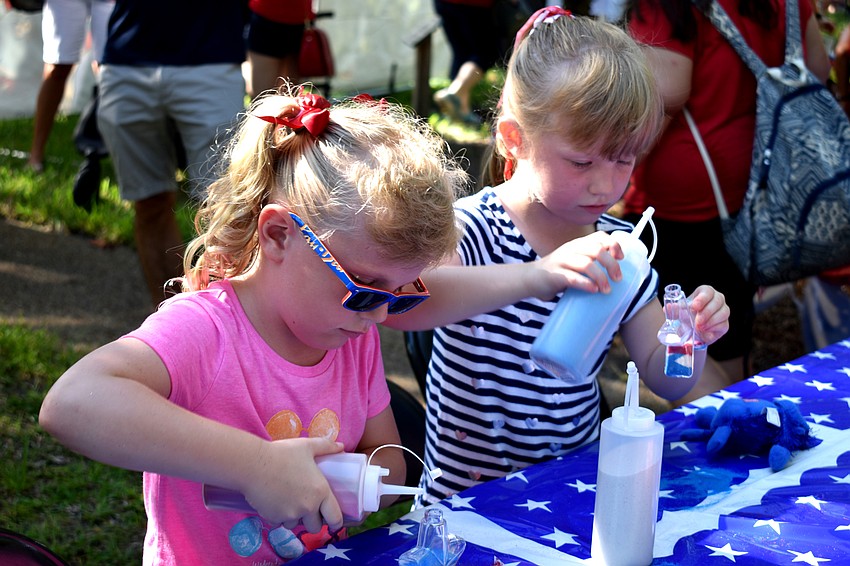 Katie and Emily Stansbury make sand art after the Freedom Fest parade.