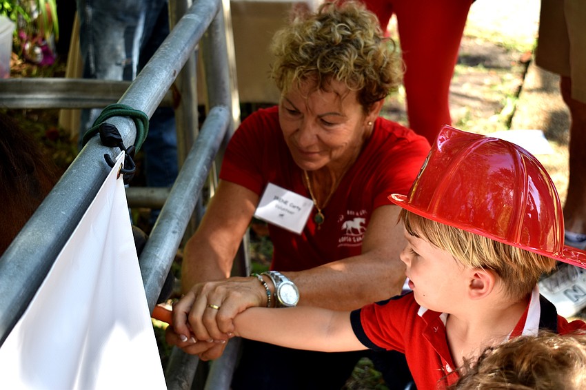 Riley Ferrari feeds a horse Sixteen Hands Horse Sanctuary, Inc.
