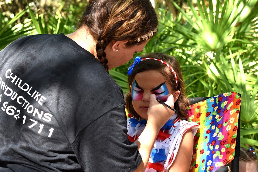 Brooke Raimonde gets her face painted following the Freedom Fest parade.